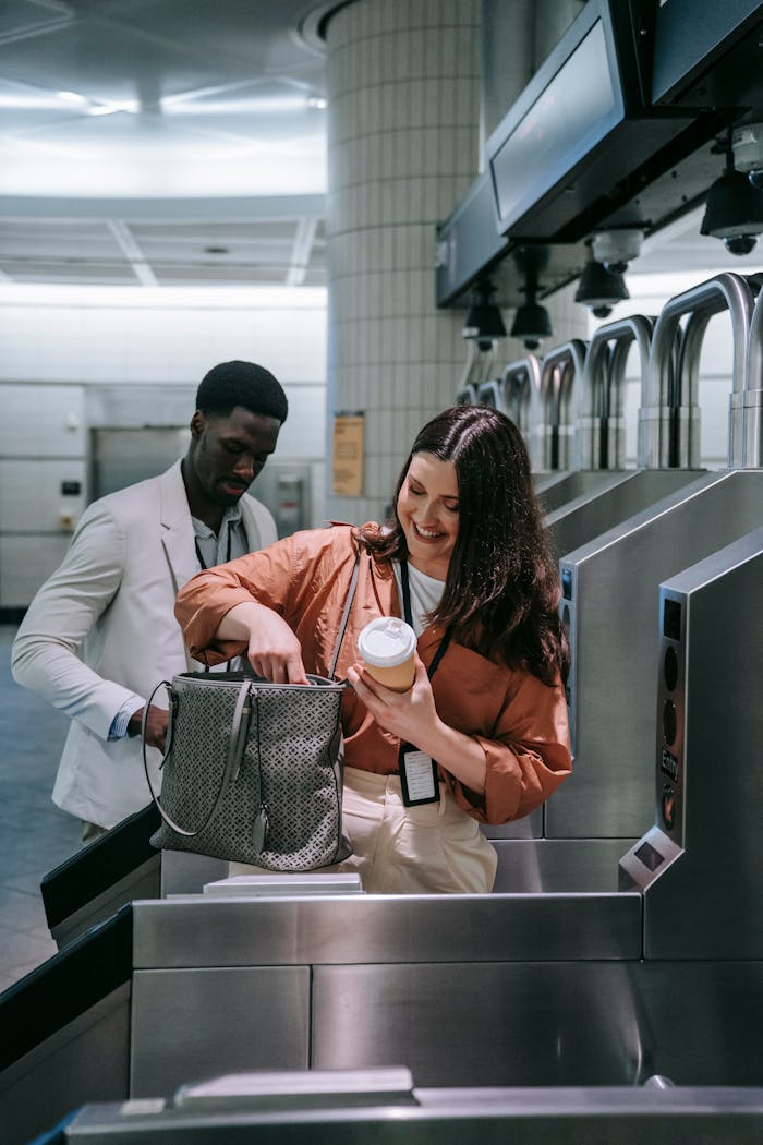 Adults passing through subway ticket gates with coffee, highlighting urban daily commute.